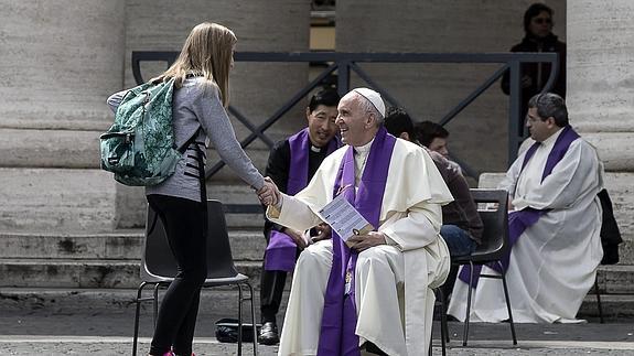 El papa Francisco confiesa a una adolescente en la Plaza de San Pedro.