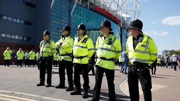 Policías vigilan el estadio de Old Trafford. 