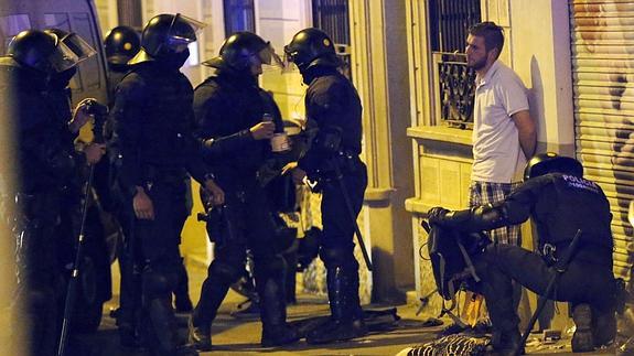 Miembros de los antidisturbios realizan un registro por las calles del barrio barcelonés de Gracia.