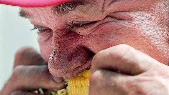 Anciano devora una mazorca de maíz.