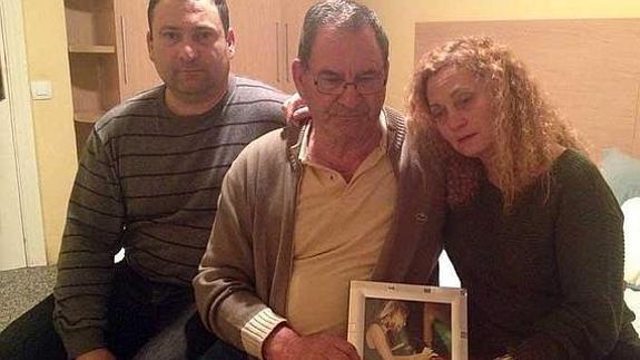 El padre de Ana, entre sus dos hijos, Antonio y Marian, sostiene una foto de la víctima.