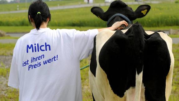 Una joven vestida con una camiseta donde puede leerse 'La leche merece su precio'. 