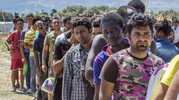 Varios inmigrantes esperan en la isla de Kos.