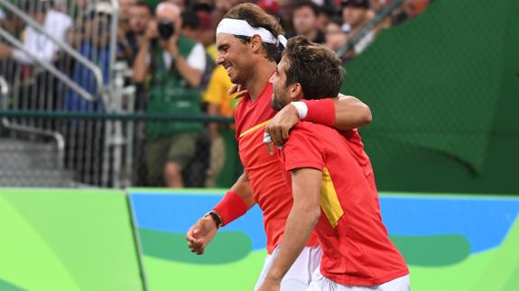 Nadal celebra la victoria con Marc López. 