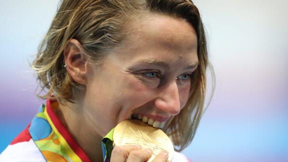 Mireia muerde la medalla. 