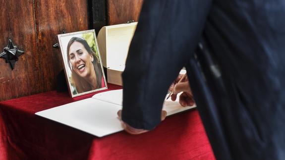 Un hombre firma en el libro de condolencias durante el funeral de María Villar. 