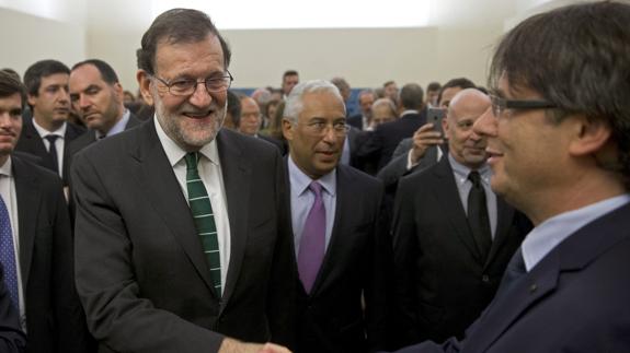 Rajoy y Puigdemont se saludan en Oporto.