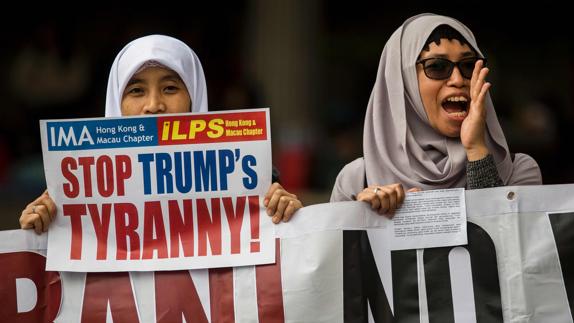 Dos mujeres protestan en Hong Kong contra la política migratoria de Trump. 