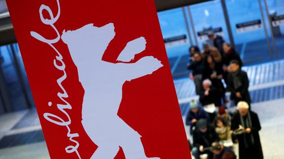 Cartel de la Berlinale ante una cola de gente que espera para comprar entradas.