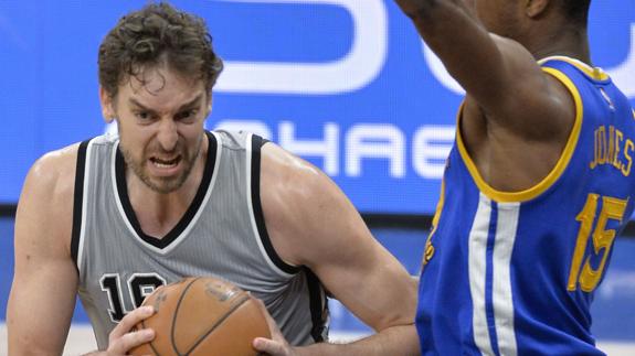 Pau Gasol (i) trata de superar la marca de Damian Jones (d), de Warriors.