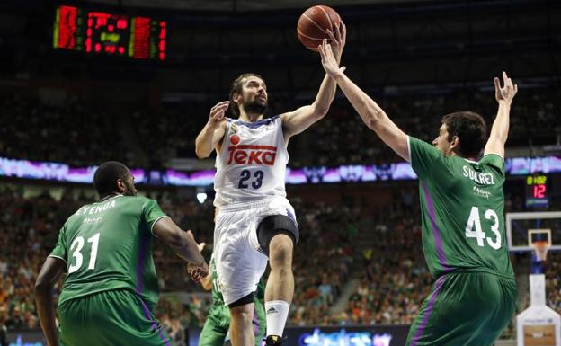 Sergio Llull entra a canasta ante Carlos Suárez. 