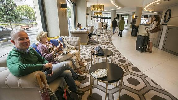Turistas en la recepción de un hotel en Santander. 