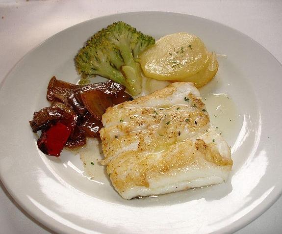 Plato de merluza al horno acompañado por verduras. 