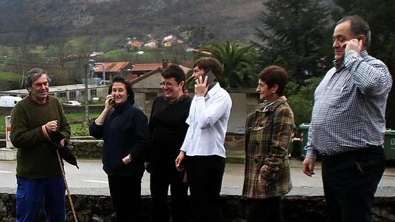 Vecinos de Puentenansa, llamando por teléfono en un punto con buena cobertura.