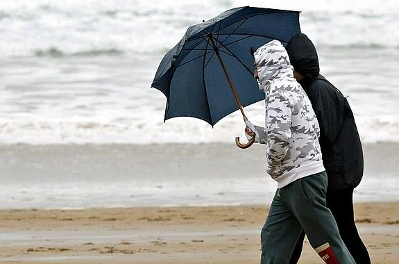 Imagen de dos jóvenes paseando por la playa de El Sardinero.