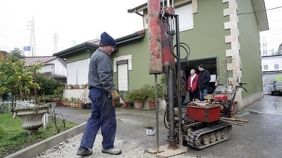 Un operario realiza pruebas junto a una de las casas de la Turbera afectadas por las filtraciones de agua hace ahora un año