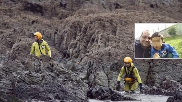 Dos efectivos de Bomberos de Asturias rastrean las rocas de la playa de Frejulfe, aprovechando la bajamar, en busca del pequeño de 20 meses.