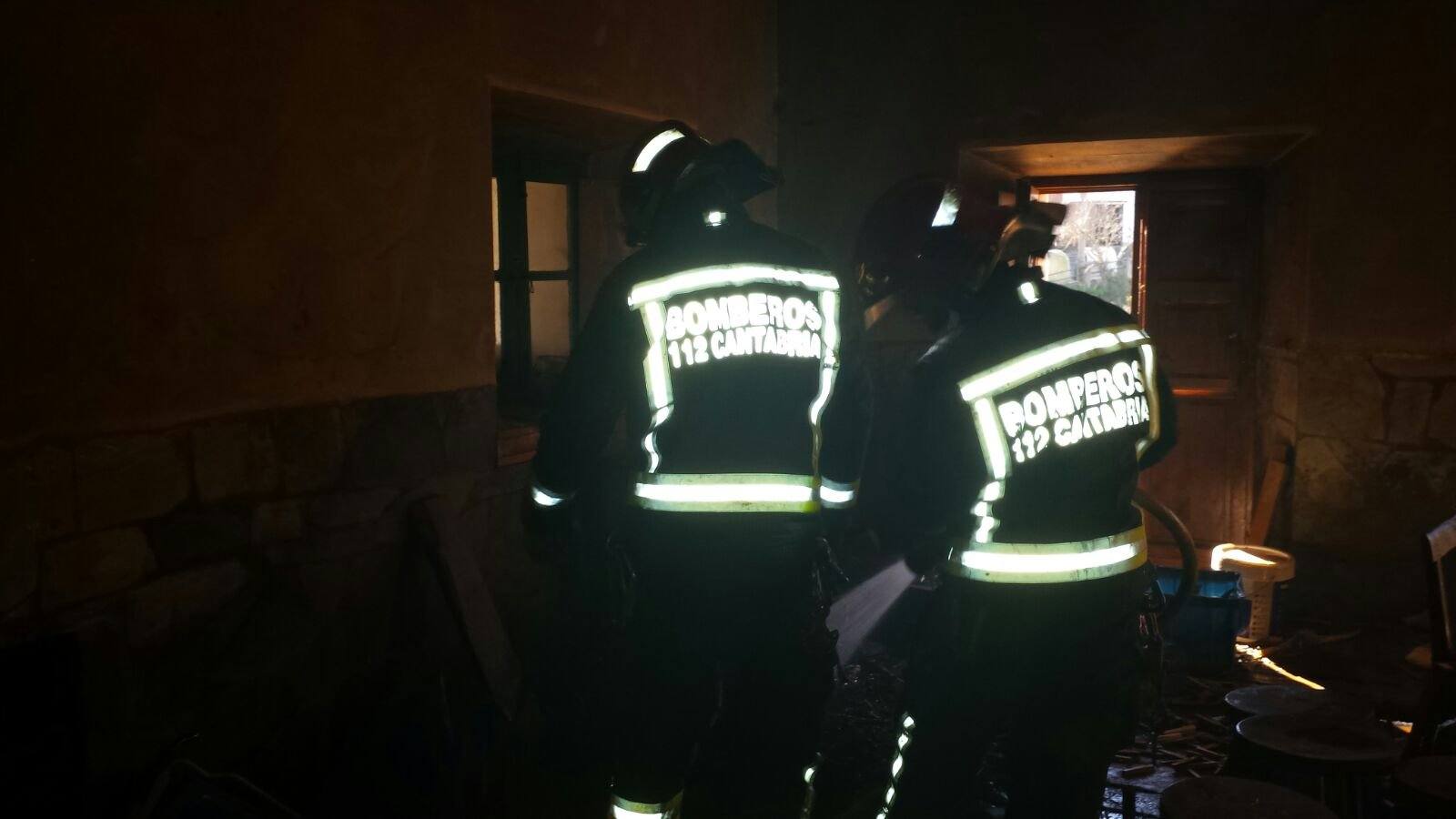 Los Bomberos en el interior de la vivienda incendiada