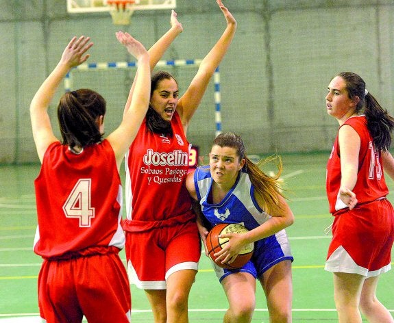 Marina Hoces, de Kells, con el balón, defendida por Manuela Fernández, Marina Carral y Marta Pérez, de Selaya. 