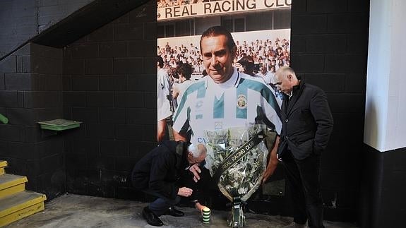 Tuto Sañudo y Manolo Higuera depositan fotos frente a la foto de Nando Yosu en los bajos del fondo norte del estadio.