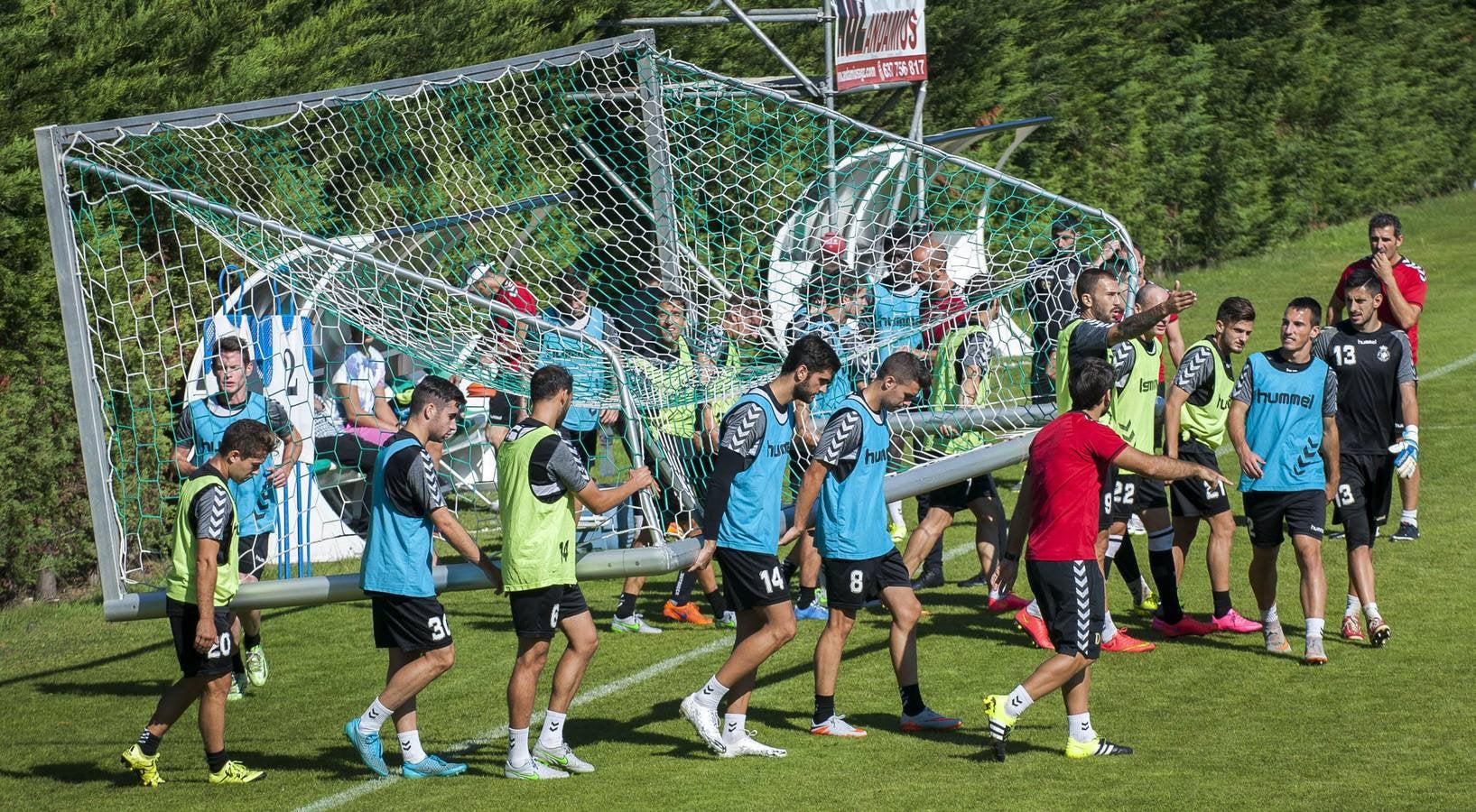 Los jugadores del Racing transportan una portería durante un entrenamiento en las Instalaciones Nando Yosu de La Albericia