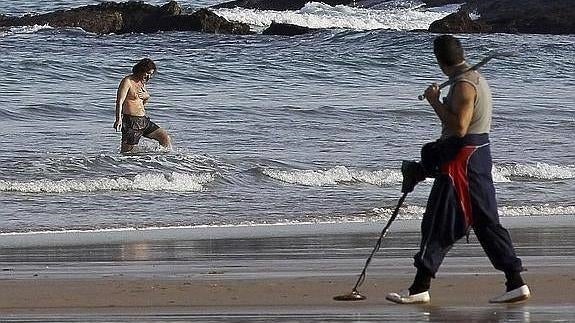 Un buscador de oro rastrea con su máquina la playa de El Camello, en Santander. 