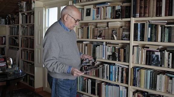 El cineasta y escritor Mario Camus en su casa de Riuloba ante su biblioteca. 