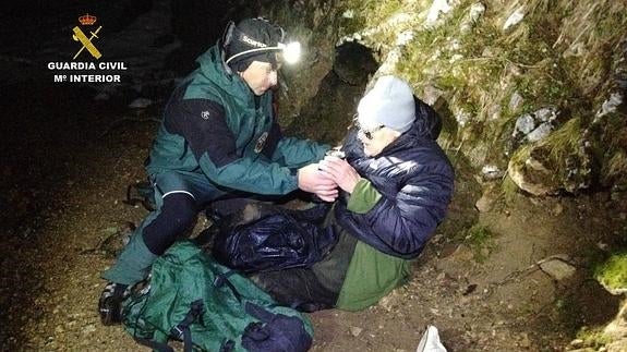 El agente da bebida caliente al hombre para entrar en calor.