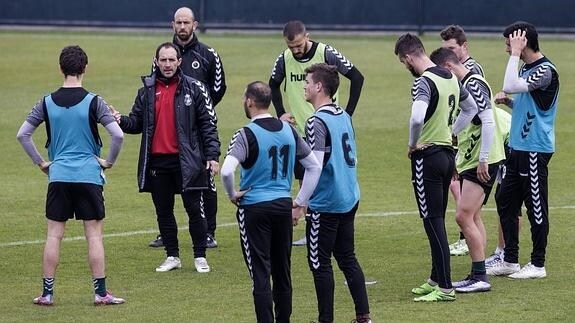 Munitis, rodeado de sus jugadores, comienza una charla en el entrenamiento de ayer en La Albericia.