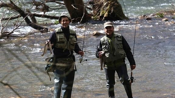 Christian Rivas (izquierda) y Raúl Anuarbe, en el Saja a su paso por Caranceja, muestran algunas de las truchas capturadas. 