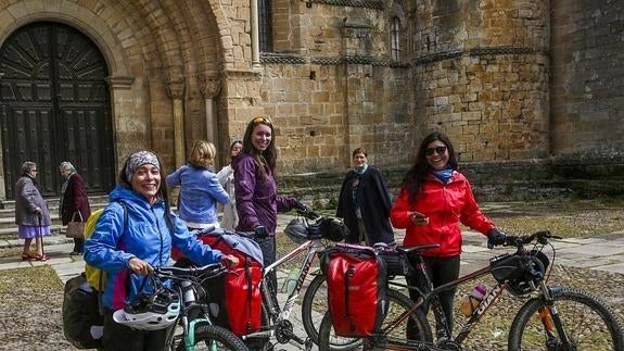 Un grupo de visitantes llegó ayer en bicicleta a las puertas de la Colegiata de Santillana del Mar.