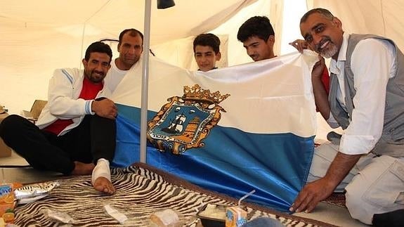 Naser junto a otros compatriotas afganos y un iraní, en su tienda del campamento de Malakasa.