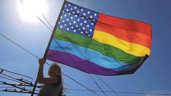 Una mujer ondea la bandera del orgullo gay en San Francisco.