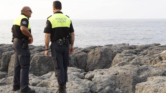 Dos policías, en el acantilado entre las playas de Ris y Trengandín.