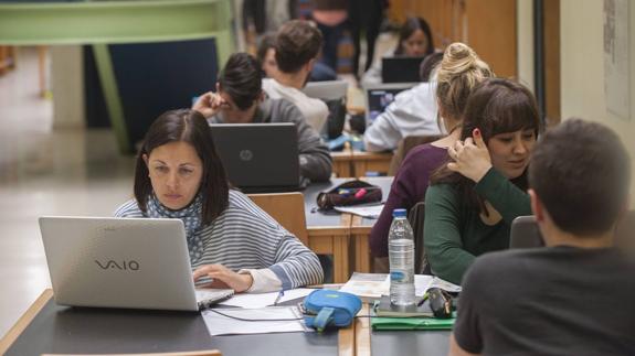 Estudiantes con sus ordenadores portátiles, en una biblioteca de la Universidad de Cantabria