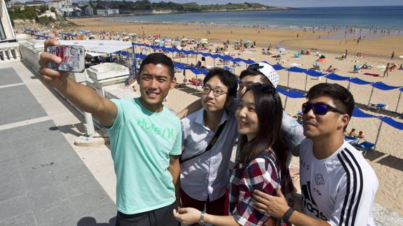 Unos turistas se fotografían en la primera plaza de El Sardinero.