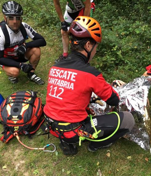 Uno de los restacadores del 112 atiende sobre el terreno al ciclista herido.