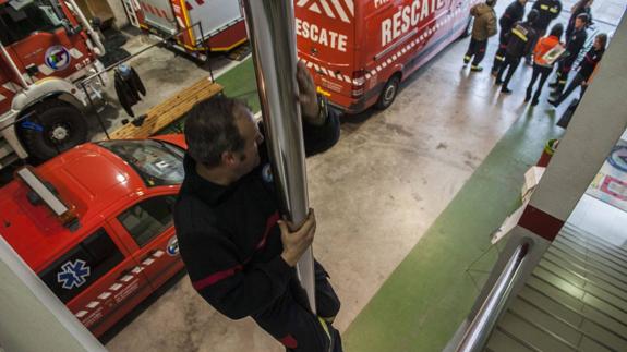 Un bombero de la ya extinta agrupación de voluntarios desciende por la barra hasta el garaje.