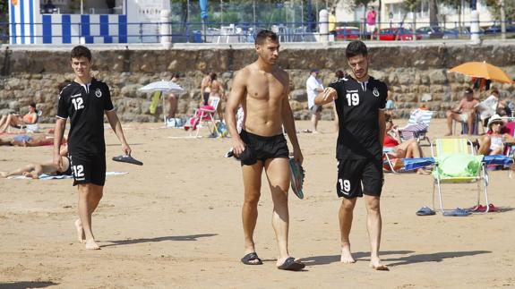 Alberto, Samuel y Caye Quintana pasean por la arena de la Segunda playa de El Sardinero camino de la orilla. La jornada playera fue un respiro para todos.