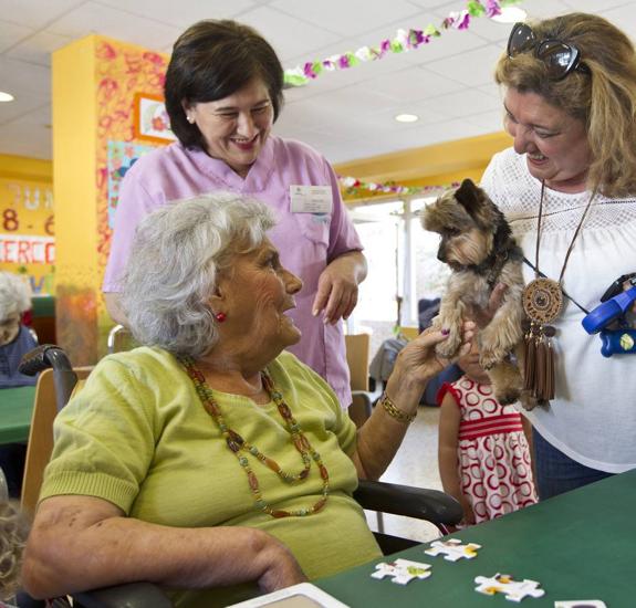 Una mujer participa en una actividad con animales de compañía en el Centro de Día de Parayas.