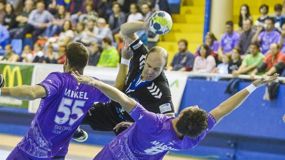 Óscar Río intenta un lanzamiento ante la oposición de dos jugadores del Guadalajara en el encuentro de ayer