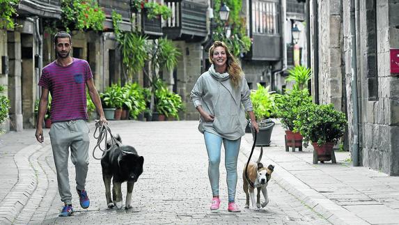 Dos jóvenes, Isaac y Eva, pasean con sus mascotas por las calles de Cartes.