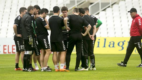 Ángel Viadero sigue de cerca una charla de los jugadores en el entrenamiento de ayer en El Sardinero.