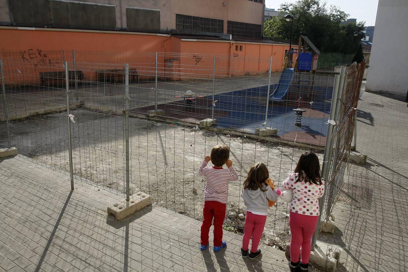 Unos niños contemplan la obra de ampliación del parque infantil de la calle Pancho Cossío, parada desde hace varios meses. :: 