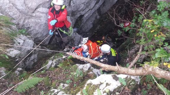 Los rescatadores suben al herido en la camilla.