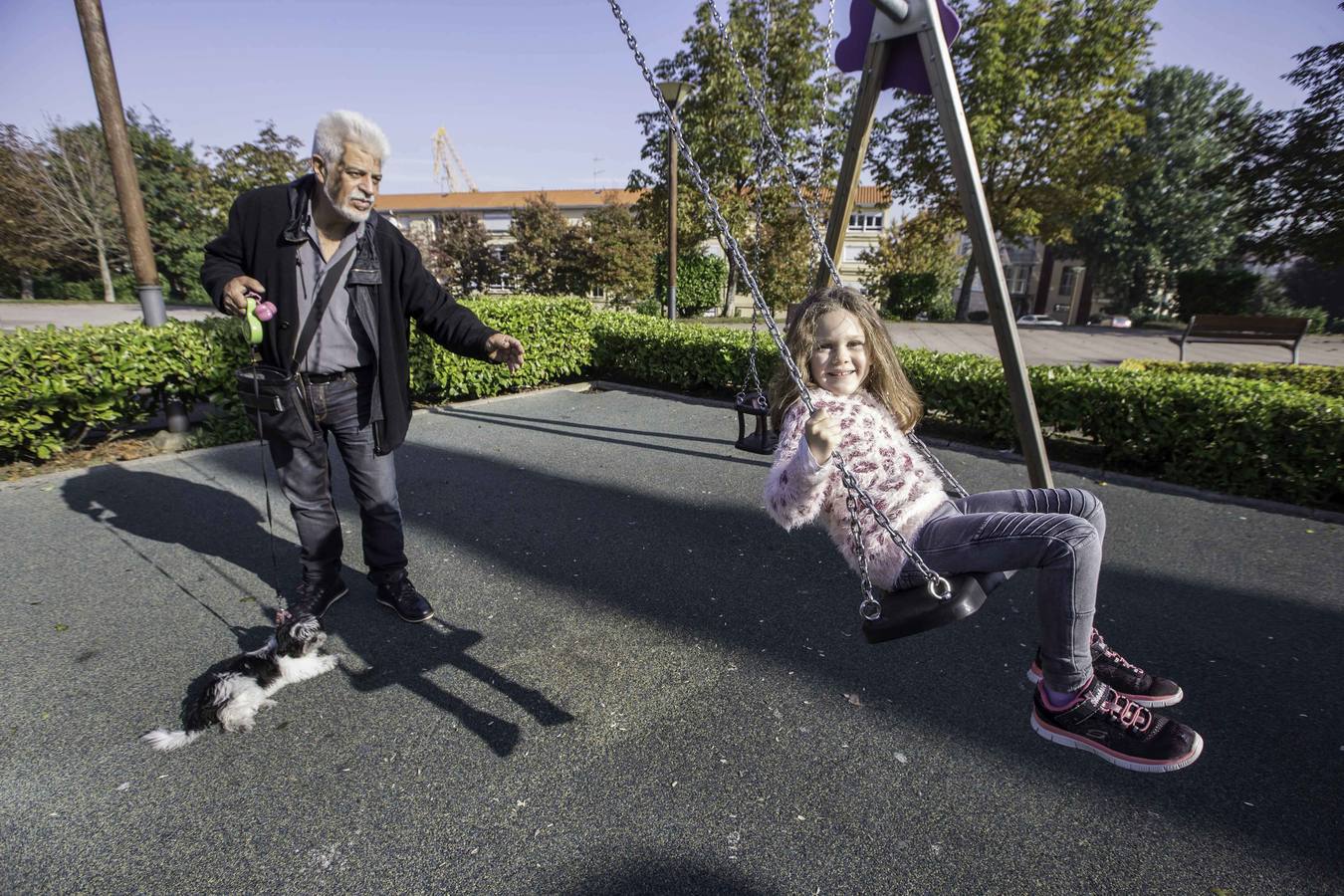 Un abuelo con su nieta en un parque infantil de Astillero