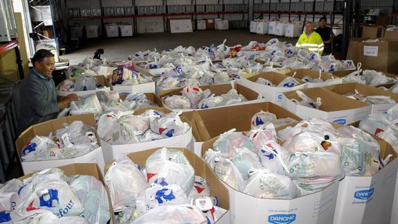 En el almacén de Tanos, cedido por el Gobierno de Cantabria, los voluntarios no pierden un minuto en clasificar los alimentos. 