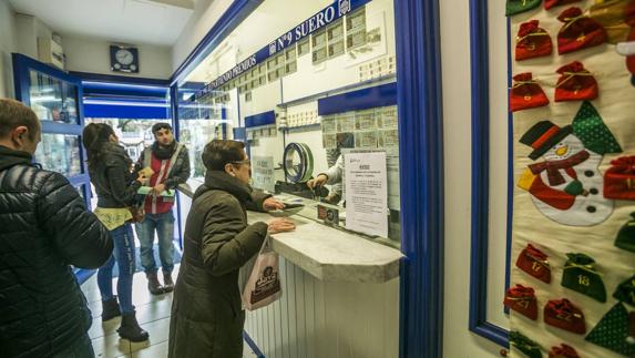 Clientes en el interior de la Administración de Lotería Suero situada en el Paseo Pereda de Santander.