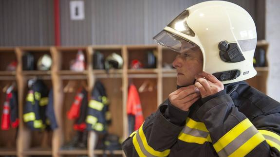 Una de las agentes del cuerpo se ajusta su casco en las instalaciones de los bomberos de Camargo.