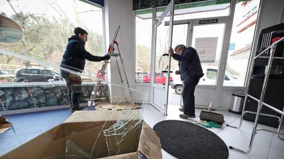 Dos operarios reparan los destrozos causados por los ladrones en el establecimiento Agro-Recambios el pasado mes de enero.